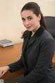 A woman in a business suit sitting at a desk.