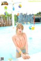 A woman in a bikini sitting in a swimming pool.