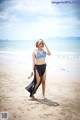 A woman in a bikini standing on a beach.