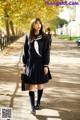 A woman in a school uniform is walking down the street.